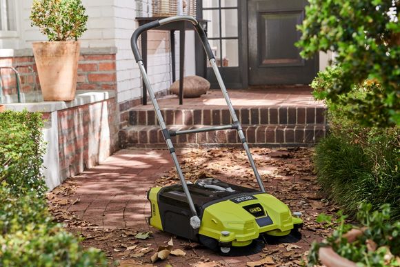 Kehrmaschine auf einem Gehweg mit Laub